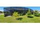 Landscaped backyard with a screened lanai, offering a private outdoor living space at 3907 Golden Knot Dr, Kissimmee, FL 34746