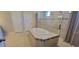 Bright bathroom featuring a soaking tub and glass enclosed shower with neutral tile and modern finishes at 3907 Golden Knot Dr, Kissimmee, FL 34746