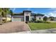 Charming single-story home with a brick driveway, gray exterior, tiled roof, and well-maintained landscaping at 3907 Golden Knot Dr, Kissimmee, FL 34746