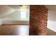 An attic space with exposed brick accents, finished floor, and a centered window at 701 1St Ne St, Fort Meade, FL 33841