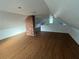 Bright attic space featuring wood floors, a brick column, and natural light at 701 1St Ne St, Fort Meade, FL 33841