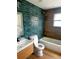 Bathroom featuring a modern vanity, toilet, tub and shower with stylish blue-green tile at 701 1St Ne St, Fort Meade, FL 33841