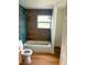 Bathroom with blue-green subway tile and a wood-look accent wall at 701 1St Ne St, Fort Meade, FL 33841