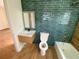 Bathroom featuring a blue-green brick tile wall and wood-look accent wall at 701 1St Ne St, Fort Meade, FL 33841