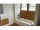 Bright bathroom featuring a tub with white subway tile and a wood-look accent wall at 701 1St Ne St, Fort Meade, FL 33841