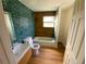 Stylish bathroom with a wood-look accent wall and blue-green brick tile at 701 1St Ne St, Fort Meade, FL 33841