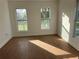 An empty bedroom features light walls, wood-look floors, and windows at 701 1St Ne St, Fort Meade, FL 33841