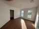 An empty bedroom features light walls, wood-look floors, and a pair of windows at 701 1St Ne St, Fort Meade, FL 33841