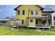 Two-story home with yellow siding, a wraparound porch, and a metal roof at 701 1St Ne St, Fort Meade, FL 33841