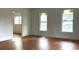 An empty living room features light walls, wood-look floors, and two windows at 701 1St Ne St, Fort Meade, FL 33841