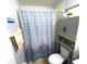 Cozy bathroom featuring a shower with a stylish curtain, and a space-saving cabinet above the toilet at 2112 Fish Eagle St, Clermont, FL 34714