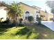 A bright, inviting home with arched windows, a well-maintained lawn, and lush landscaping at 2112 Fish Eagle St, Clermont, FL 34714