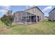 Backyard features a screened-in pool, patio with outdoor furniture, and well-maintained lawn at 712 Whistling Straits Blvd, Davenport, FL 33896