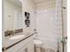 Clean bathroom with a white sink, vanity, toilet, shower, and neutral shower curtain at 712 Whistling Straits Blvd, Davenport, FL 33896