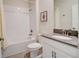 Bathroom with shower-tub combo, white tile, and a single sink vanity with countertop at 712 Whistling Straits Blvd, Davenport, FL 33896