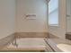Soaking tub with tile surround and a 'Bathroom Rules' sign for a relaxing and stylish bathroom experience at 712 Whistling Straits Blvd, Davenport, FL 33896