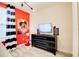 Playful bedroom features a red accent wall, fun decorations, and a dresser with a flat-screen television at 712 Whistling Straits Blvd, Davenport, FL 33896