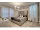 Bedroom featuring a stylish light fixture, large windows with patterned curtains, and a comfortable bed at 712 Whistling Straits Blvd, Davenport, FL 33896