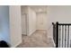 Upstairs hallway with neutral carpeting, white walls, and black railings, creating a modern and bright space at 712 Whistling Straits Blvd, Davenport, FL 33896