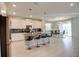 Spacious kitchen with white cabinets, granite countertops, stainless steel appliances, and bar seating at 712 Whistling Straits Blvd, Davenport, FL 33896