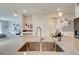 Bright kitchen featuring a large island with seating, stainless steel sink, and modern lighting at 712 Whistling Straits Blvd, Davenport, FL 33896