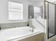 Bathroom featuring soaking tub, glass enclosed shower, and natural light at 11720 Language Way, Orlando, FL 32832