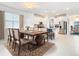 Elegant dining area with a large wooden table, seating for six, and an open concept kitchen at 11720 Language Way, Orlando, FL 32832