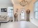 Bright foyer featuring tile flooring, chandelier, front door with wreath, and elegant decorations at 11720 Language Way, Orlando, FL 32832