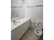 Well-lit bathroom features a vanity with a sink and a toilet in a neutral color scheme at 2846 Club Cortile Cir, Kissimmee, FL 34746
