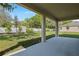 A covered patio overlooks the grassy backyard with a new fence and lush green trees at 3709 Deer Ridge Dr, Mount Dora, FL 32757