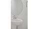 Modern bathroom showcasing a pedestal sink, round mirror, and clean, minimalist design with bright lighting at 3716 Deer Ridge Dr, Mount Dora, FL 32757
