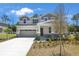 Inviting two-story home with manicured front yard, showcasing stone accents, neutral colors, and a well-kept lawn at 3716 Deer Ridge Dr, Mount Dora, FL 32757