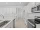 Modern kitchen showcasing white cabinetry, stainless steel appliances, subway tile backsplash, and sleek countertops at 3716 Deer Ridge Dr, Mount Dora, FL 32757