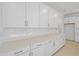 Modern kitchen featuring white cabinets, sleek countertops, a subway tile backsplash, and stainless steel hardware at 3716 Deer Ridge Dr, Mount Dora, FL 32757