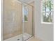 Tiled shower with a glass door, set in a light-filled bathroom with a view from the window at 3716 Deer Ridge Dr, Mount Dora, FL 32757
