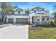 Charming two-story home boasts a three-car garage and inviting stone accents on a well-manicured front lawn at 3764 Deer Ridge Dr, Mount Dora, FL 32757