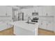 Bright kitchen featuring sleek white cabinets, a large island with a sink, and stainless steel appliances at 3764 Deer Ridge Dr, Mount Dora, FL 32757