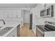 Modern kitchen offers stainless steel appliances and white cabinets with sleek countertops, creating a bright and inviting space at 3764 Deer Ridge Dr, Mount Dora, FL 32757