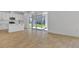 Open-concept living area with wood floors that seamlessly connects a modern kitchen with large sliding glass doors to the outside at 3764 Deer Ridge Dr, Mount Dora, FL 32757