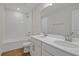 Bathroom with tub, double vanity, and wood-look tile floor at 1461 August Gray Dr, Kissimmee, FL 34744