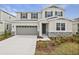 Two-story house with gray siding, stone accents, and a two-car garage at 1461 August Gray Dr, Kissimmee, FL 34744