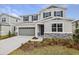 Two-story house with gray siding, stone accents, and a two-car garage at 1461 August Gray Dr, Kissimmee, FL 34744
