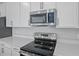 Stainless steel appliances and white cabinets in a modern kitchen at 1461 August Gray Dr, Kissimmee, FL 34744