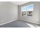 Empty bedroom featuring soft carpet, a large window, and neutral decor at 1479 August Gray Dr, Kissimmee, FL 34744