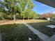 Spacious backyard with grass, mature trees, and storage sheds at 2728 Adair Rd, Davenport, FL 33837