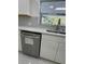 Updated kitchen with a stainless steel dishwasher, gray backsplash, and stone countertops at 2728 Adair Rd, Davenport, FL 33837