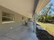 Long covered porch with rocking chair and backyard access at 2728 Adair Rd, Davenport, FL 33837