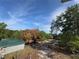 Image of the treed and grassy property and metal carports at 2728 Adair Rd, Davenport, FL 33837