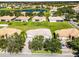 An aerial view of the home showcases its tile roof, landscaping, and a neighborhood lake at 3643 Weatherfield Dr, Kissimmee, FL 34746