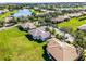 An aerial view of the neighborhood showcasing lush landscaping and a community lake at 3643 Weatherfield Dr, Kissimmee, FL 34746
